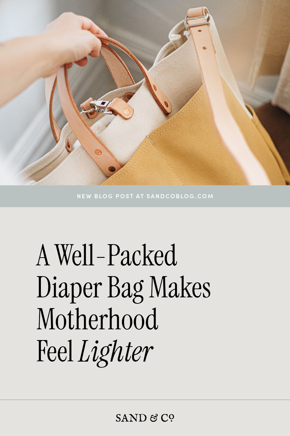 Hand holding neutral tote diaper bag