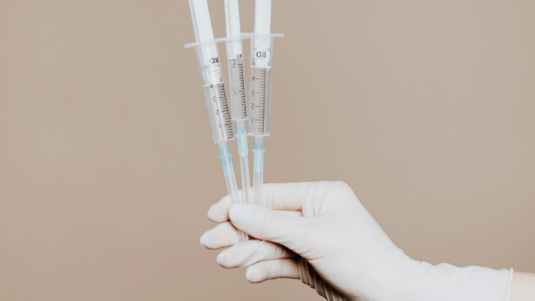 Gloved hand holding medical needles