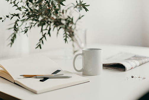 Coffee cup and mom notebook with pens